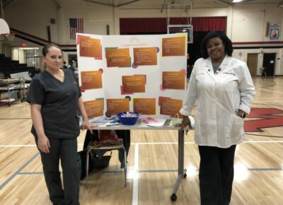 Doctor Smith and a nurse standing in front of a table for family fun night